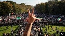Seorang pria memberi isyarat dengan dua jarinya saat berlangsungnya aksi protes terhadap rezim Iran, di Berlin, Jerman, 22 Oktober 2022, menyusul kematian Mahsa Amini dalam tahanan "polisi moral" republik Islam yang terkenal itu.