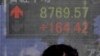 A man looks at the stock price board on a street in Tokyo, Japan, March 16, 2011.