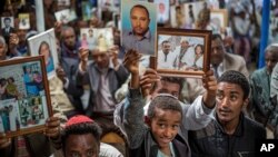 Members of Ethiopia's Jewish community hold pictures of their relatives in Israel, during a solidarity event at the synagogue in Addis Ababa, Ethiopia, Feb. 28, 2018. 