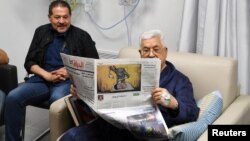El presidente palestino Mahmoud Abbas lee un periódico en un hospital de Ramala el 21 de mayo.