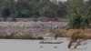 FILE - In this June 20, 2016, file photo, a fishing boat passes near a construction site of the Don Sahong dam, near Cambodia-Laos borders, in Preah Romkel village, Stung Treng province, northeast of Phnom Penh, Cambodia. The Mekong River Commission, an organization that groups together Laos, Cambodia, Vietnam, and Thailand for joint management of the river, said in a statement it has received notice from Laos that it will undertake a process of consultation about the Pak Beng dam. (AP Photo/Heng Sinith, File)