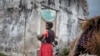 FILE - A woman holds her child at a makeshift camp for internally displaced persons (IDPs) among old abandoned buildings in Kalemie, Tanganyika province, Democratic Republic of the Congo, Sept. 18, 2017.