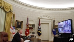 El presidente Donald Trump saluda a miembros de las cinco ramas del ejército, a través de una videoconferencia, el día de Navidad, el martes 25 de diciembre de 2018.