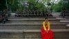 A woman in a traditional Korean Hanbok costume sits in front of South Korean soldiers at Namsangol Hanok Village in Seoul, May 20, 2013. 