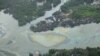FILE -Oil is seen on the creek water's surface near an illegal oil refinery in Ogoniland, outside Port Harcourt, in Nigeria's Delta region, March 24, 2011.