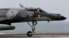 FILE - A French military plane lands on the French navy aircraft carrier Charles de Gaulle in the Persian Gulf, March 18, 2015. France has fired its first airstrikes in Syria as it expands military operations against Islamic State extremists, President Francois Hollande's office announced, Sept. 27, 2015.
