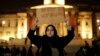 A woman holds up a sign at a vigil for the victims of Wednesday's attack, at Trafalgar Square in London, March 23, 2017. The Islamic State group has claimed responsibility for an attack by a man who plowed an SUV into pedestrians and then stabbed a police officer to death.