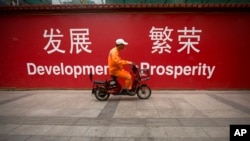 中国清洁工骑车经过标语牌（2015年7月15日）