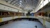 Seorang perempuan mengenakan masker, berlatih skating gaya bebas di arena seluncur es yang biasanya ramai dengan skater di sebuah pusat perbelanjaan di Beijing, Minggu, 18 Desember 2022. (AP/Andy Wong)