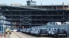 Cars readied for export are parked next to a vehicle storage facility on the dockside at the ABP port in Southampton, Britain, Aug. 16, 2017. 
