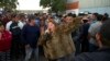 Mirna Contreras, de Honduras, canta mientras otros migrantes esperan en la cola para cenar en un albergue donde viven los miembros de la caravana de migrantes, en Tijuana, México, el lunes 26 de noviembre de 2018.