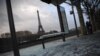 Un autobús dañado detenido en París y al fondo la torre Eiffel, un día después de protestas de los "chalecos amarillos", en el cuarto fin de semana de disturbios. Domingo, 9 de diciembre de 2018. 