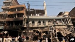 Pakistani rescue workers, police officers and civilians gather at the site of a car bomb explosion in Peshawar, Pakistan, Sept. 29, 2013. 