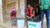Des agents électoraux scellent des urnes vides devant un bureau de vote avant l'ouverture de celui-ci pour les élections législatives et régionales du Togo, à Lomé, Togo, le 29 avril 2024. 