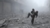 A wounded man is carried following an air strike on the rebel-held besieged town of Arbin, in the eastern Ghouta region on the outskirts of the capital Damascus on January 2, 2018.