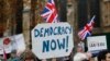 FILE - Pro-Brexit demonstrators wave flags and banners outside Parliament in London.