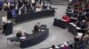 German Chancellor Angela Merkel, left, addresses lawmakers on the decisions of the EU summit at the parliament Bundestag in Berlin, June 29, 2012.