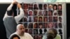 Relatives of the deceased and people directly affected by the Grenfell Tower fire, sit in front of a photo montage of the those who died, as they react to the final report into the fire being released in London, Sept. 4, 2024. 
