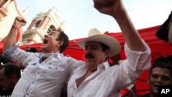 Opposition leader Salvador Nasralla, left, cheers along with former President Manuel Zelaya, at a rally where he reaffirmed his claim on the presidency of Honduras, in the central park of San Pedro Sula, Honduras, Jan. 6, 2018. 