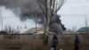 Volodymyr (61) dan Nataliia Bolias (51), berjalan melewati sebuah bangunan industri terkena serangan rudal pada Hari Natal di garis depan di Bakhmut, Ukraina, 25 Desember 2022. (REUTERS/Clodagh Kilcoyne)