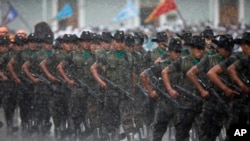 Soldados marchando bajo la lluvia durante una ceremonia militar en reconocimiento del nuevo presidente de Guatemala, Alejandro Maldonado, el 4 de septiembre, de 2015.