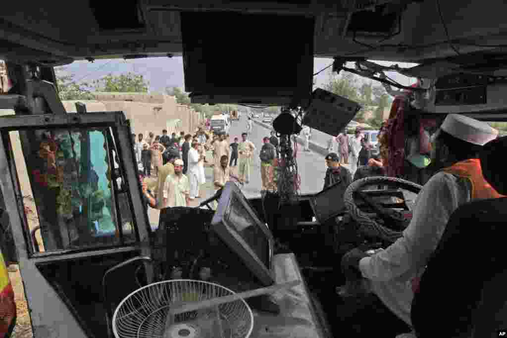 A rescue worker inspects the wreckage of a bus that was destroyed in a bomb blast, Peshawar, Pakistan, Sept. 27, 2013.